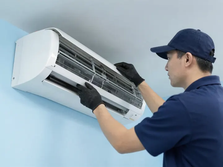 Técnico abrindo o painel de um split para a manutenção